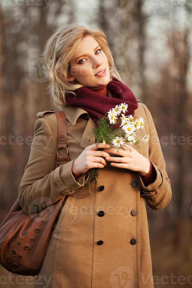 giovane donna con fiori nella foresta di autunno foto