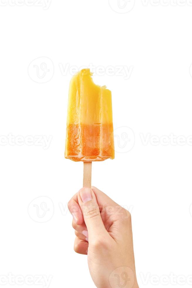 Bitten giallo congelato frutta ghiaccio crema ghiacciolo nel donna mano su bianca sfondo foto