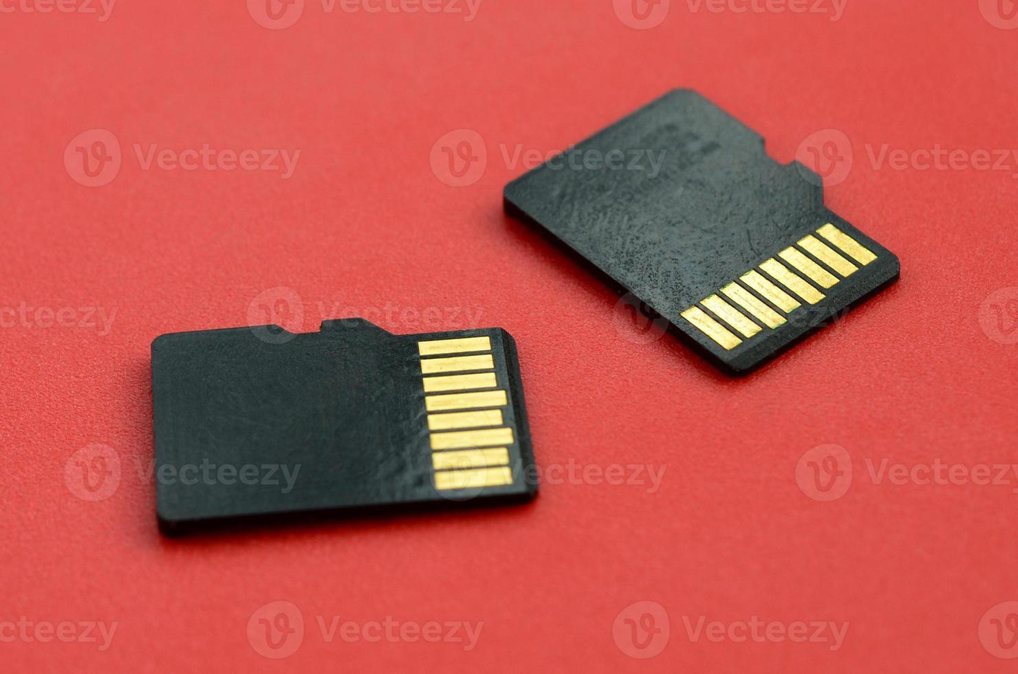 Due piccolo micro sd memoria carte menzogna su un' rosso sfondo. un' piccolo e compatto dati e informazione memorizzare foto