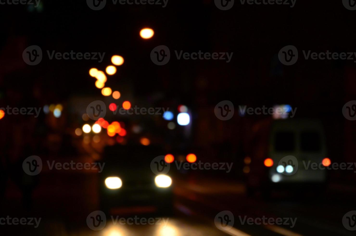 sfocato notte scena di traffico su il carreggiata. sfocato Immagine di macchine in viaggio con luminoso fari. bokeh arte foto