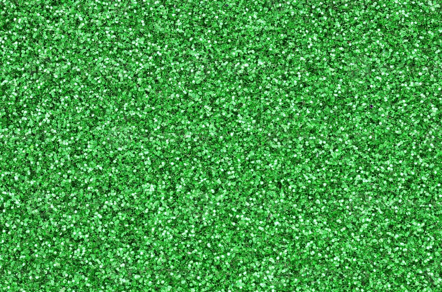 un' enorme quantità di verde decorativo paillettes. sfondo Immagine con brillante bokeh luci a partire dal piccolo elementi foto