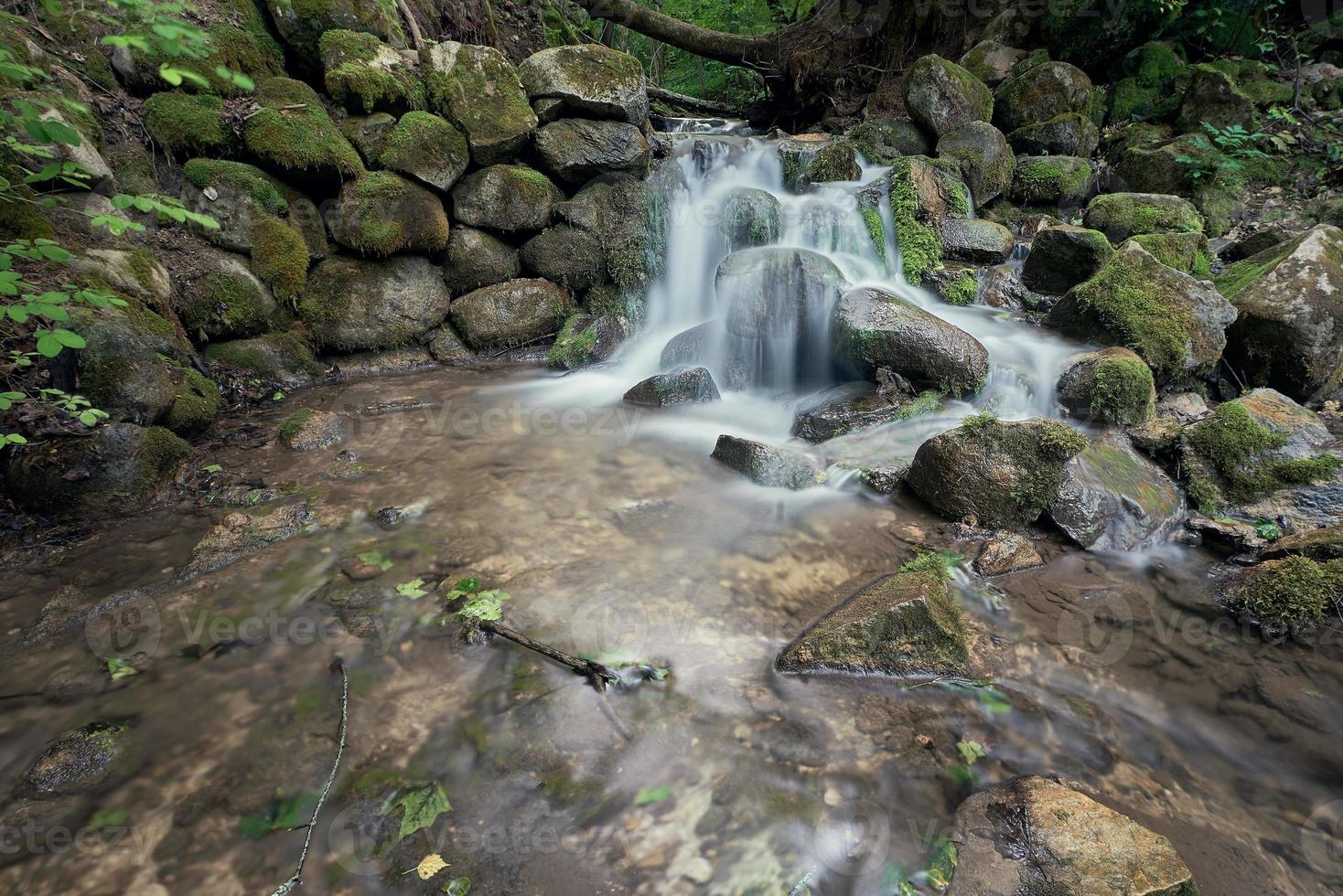 mulino torrente nel il verde foresta. caduta acqua a lungo esposizione su il luogo di un vecchio rovinato mulino. foto