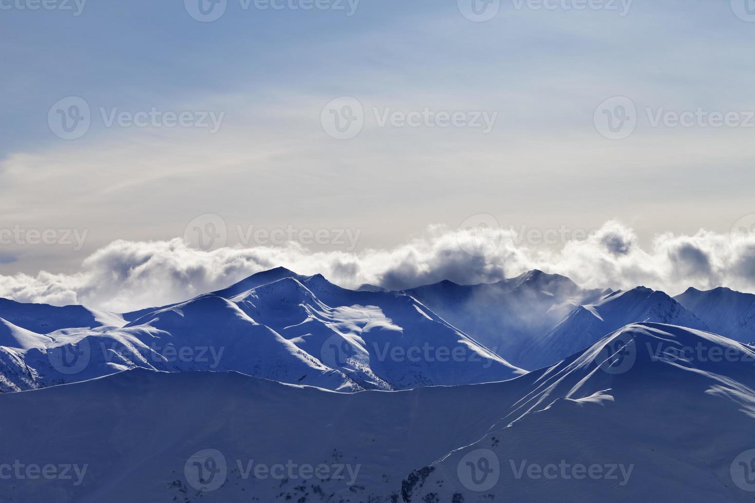 sera inverno montagne e nuvole di luce solare foto
