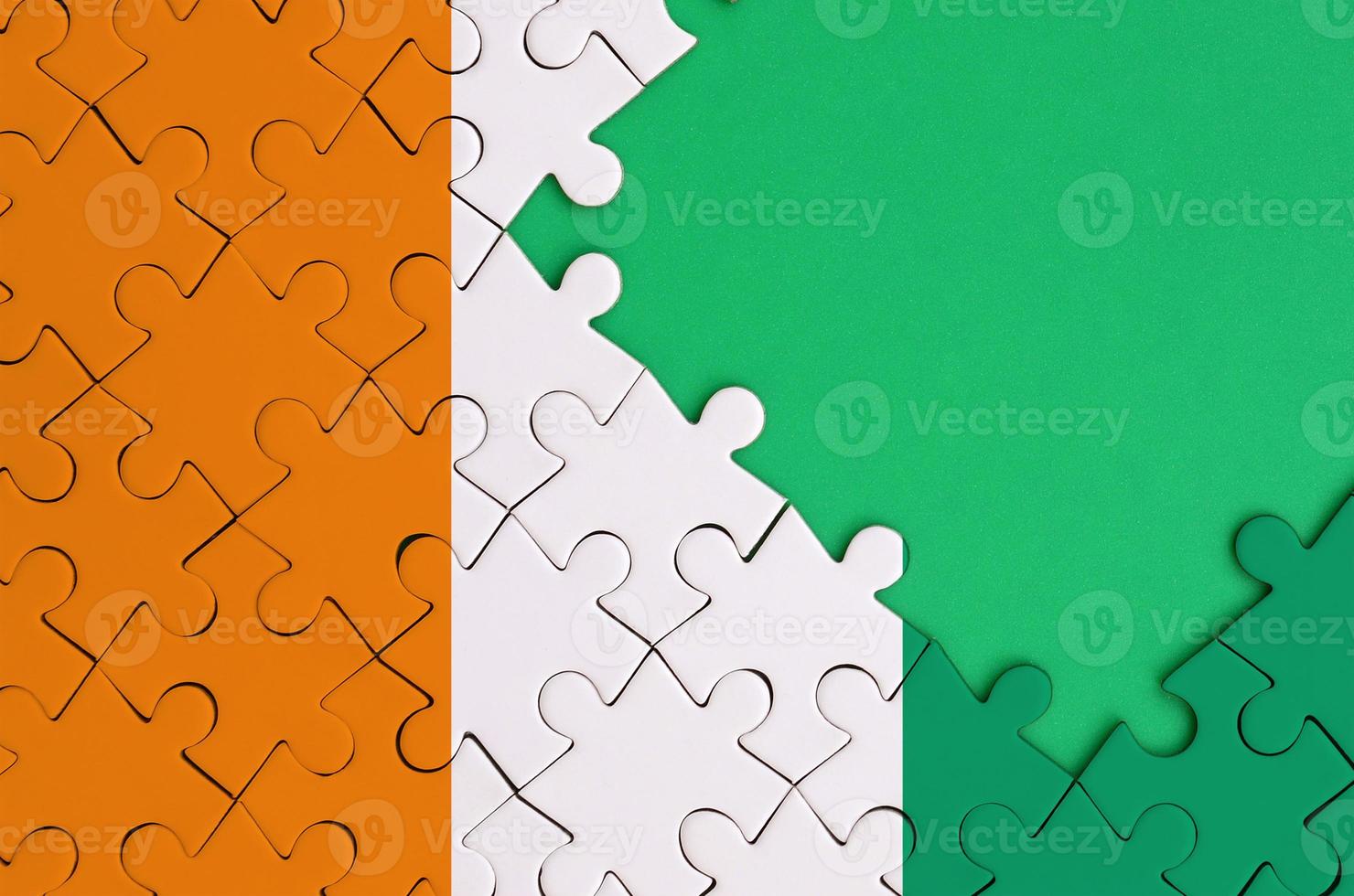 avorio costa bandiera è raffigurato su un' completato sega puzzle con gratuito verde copia spazio su il giusto lato foto