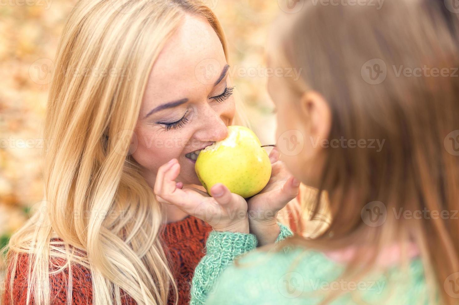 ragazza con madre mangiare Mela foto