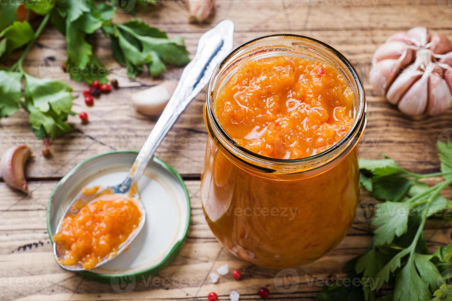 fatti in casa caviale a partire dal zucchine pomodori e cipolle nel un' bicchiere vaso su un' di legno sfondo. fatti in casa produzione conserve, in scatola in umido verdura. foto