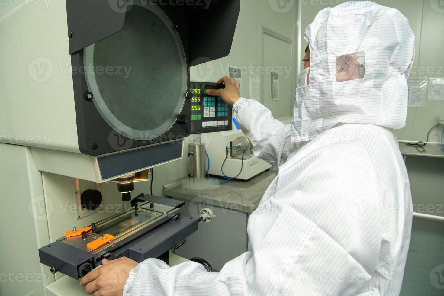 il lavoratore nel il laboratorio per il produzione e qualità controllo di il interno parti di medico siringhe foto