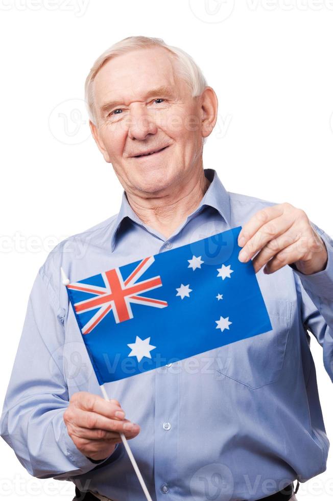 Nonno a partire dal Australia. allegro anziano uomo Tenere bandiera di Australia e sorridente a telecamera mentre in piedi contro bianca sfondo foto