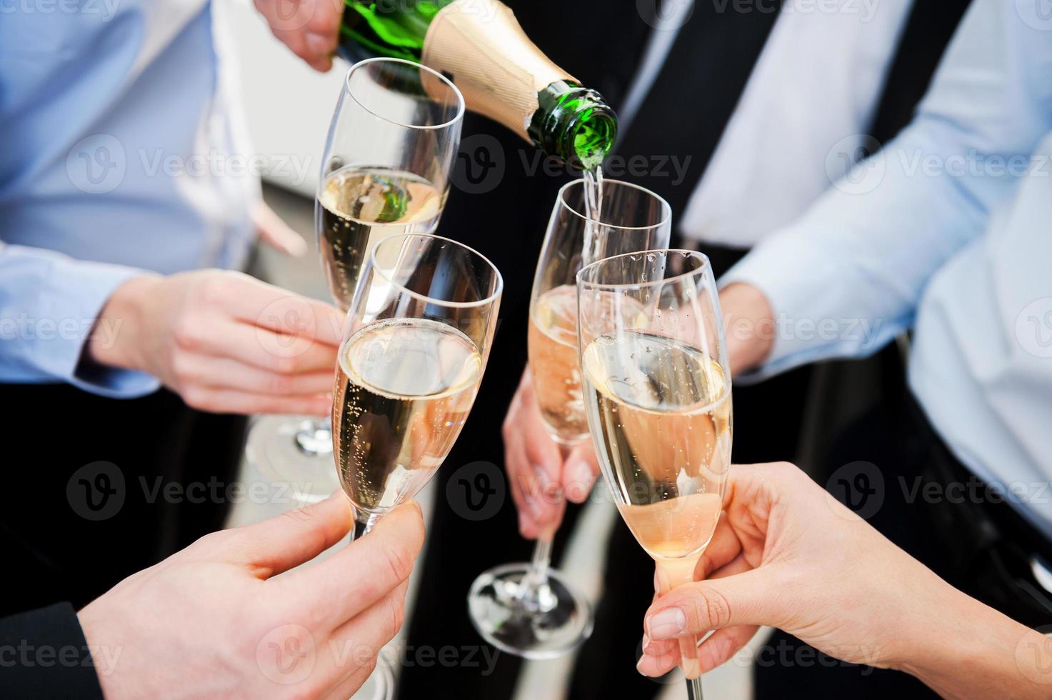 festeggiare grande successo. avvicinamento di attività commerciale persone Tenere flauti con Champagne e tostatura foto