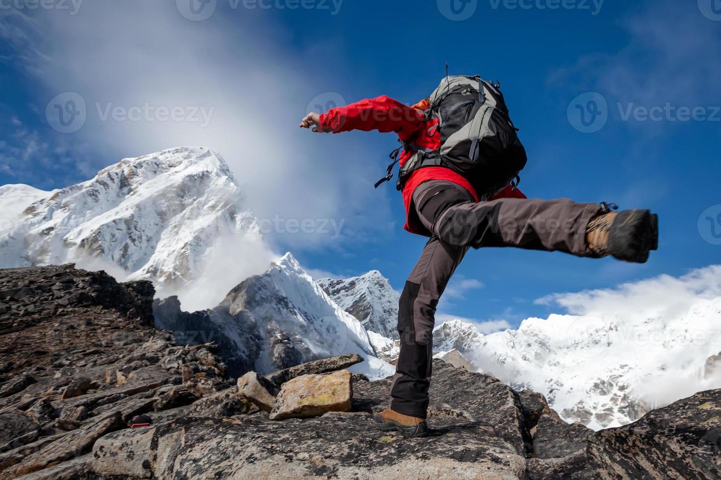 escursionista salta nelle montagne dell'Himalaya foto