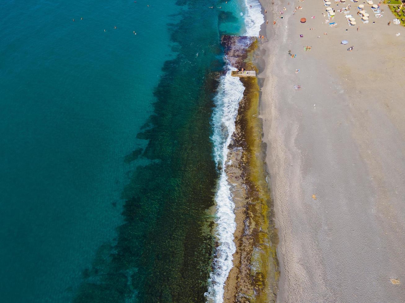 mare aereo Visualizza, superiore Visualizza, sorprendente natura sfondo. acqua colore e bellissimo luminosa. roccioso riva e chiaro acqua di il mare su un' soleggiato giorno volante drone, paesaggio marino foto