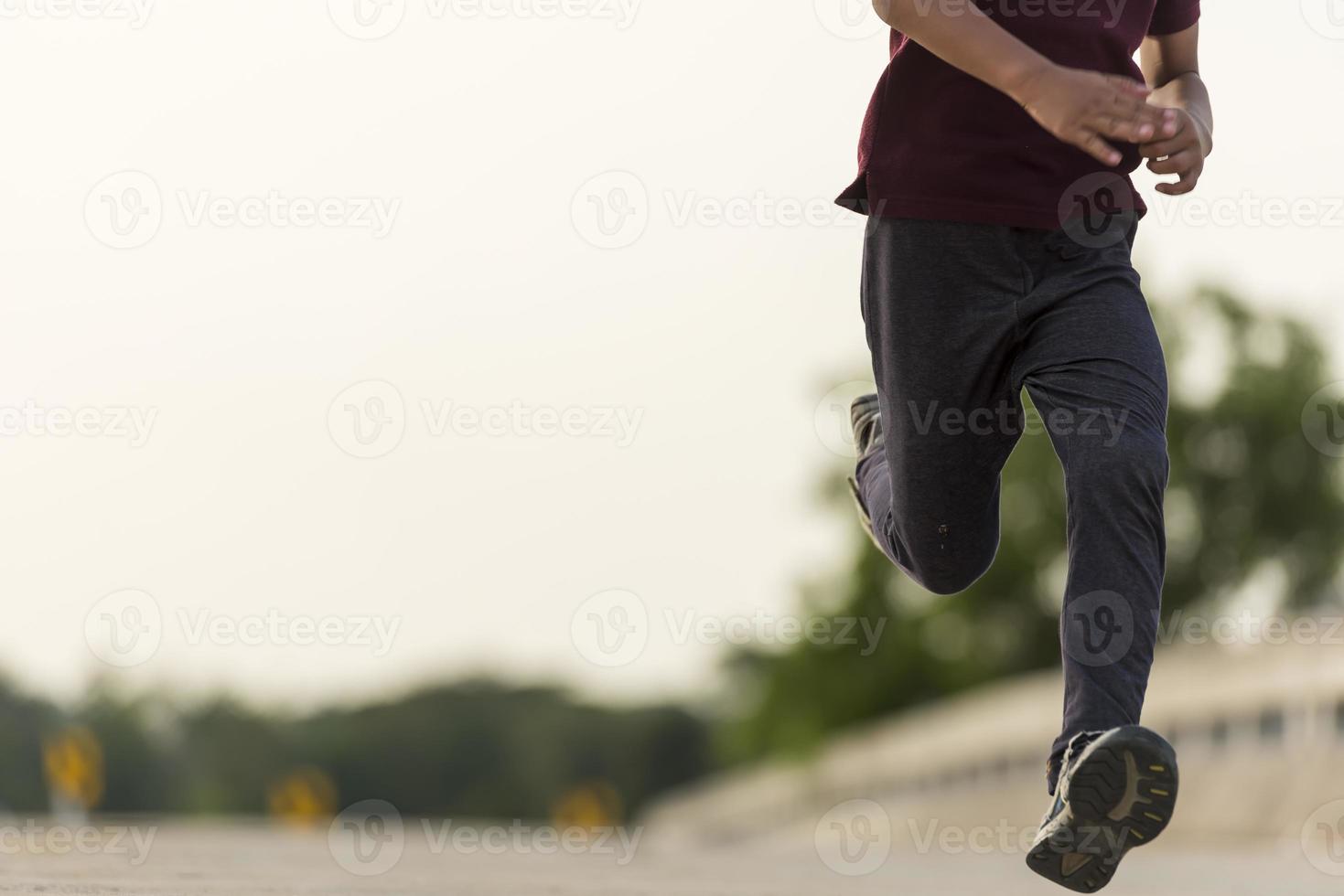 un' poco ragazzo corre lungo il ponte. foto