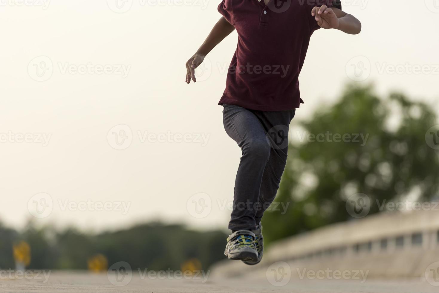 un' poco ragazzo corre lungo il ponte. foto