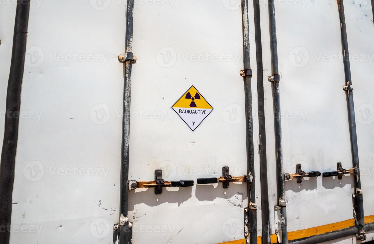 Segnale di pericolo di radiazioni sull'etichetta di trasporto di merci pericolose classe 7 presso il contenitore del camion di trasporto foto