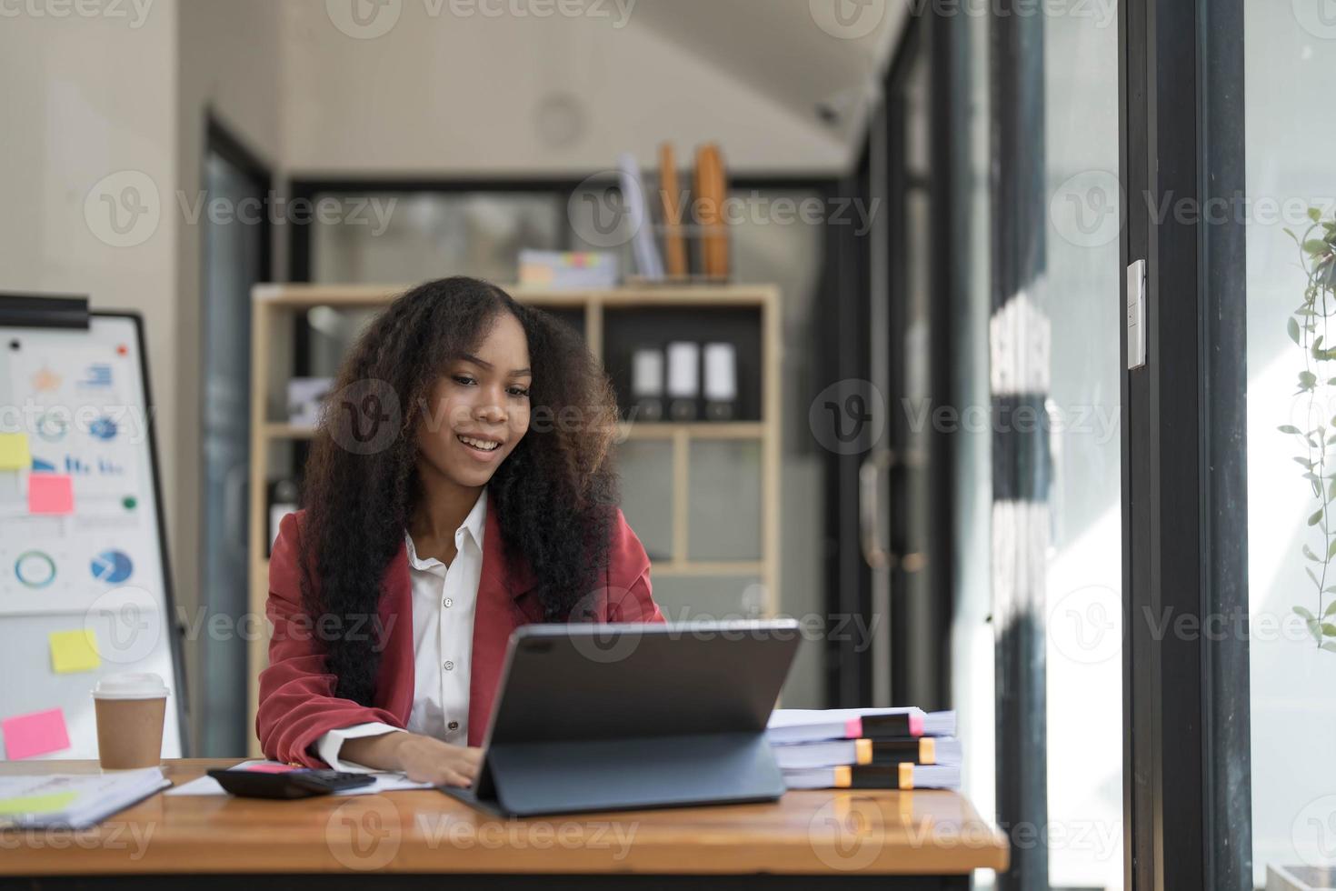 asiatico attività commerciale donna utilizzando calcolatrice e il computer portatile per fare matematica finanza su un ufficio scrivania, imposta, rapporto, contabilità, statistiche, e analitico ricerca concetto foto