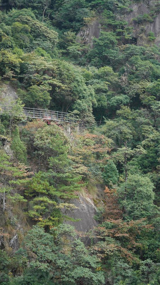 il bellissimo montagne paesaggi con il verde foresta e un' tavola strada costruito lungo il viso di un' scogliera nel il campagna di il Cina foto