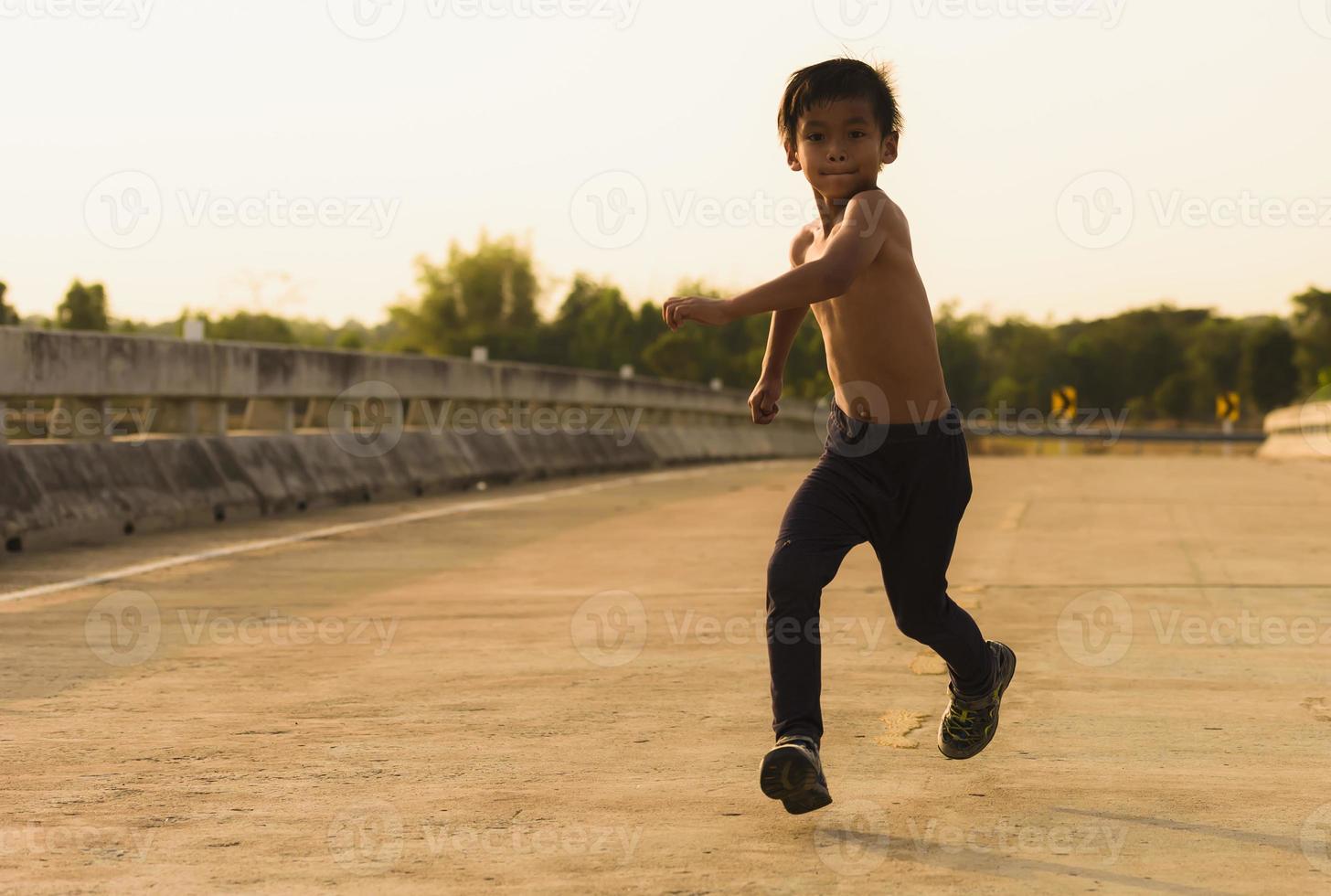 un' forte poco ragazzo corse lungo il ponte. foto