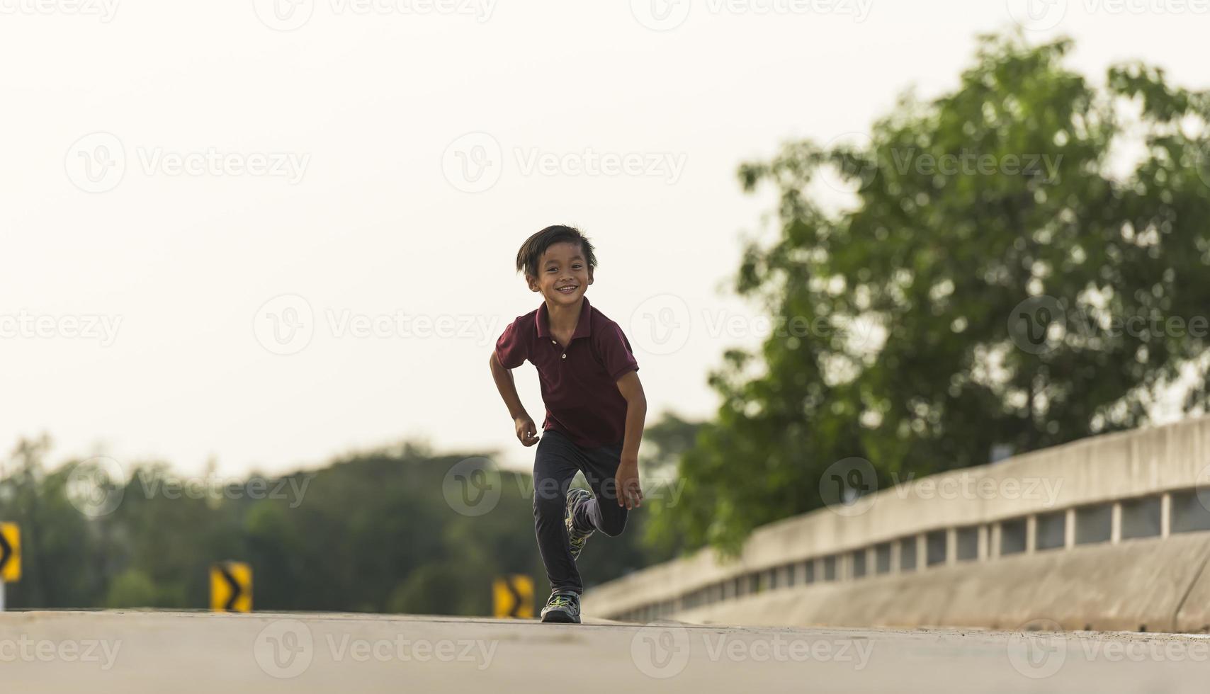 un' poco ragazzo corre lungo il ponte. foto