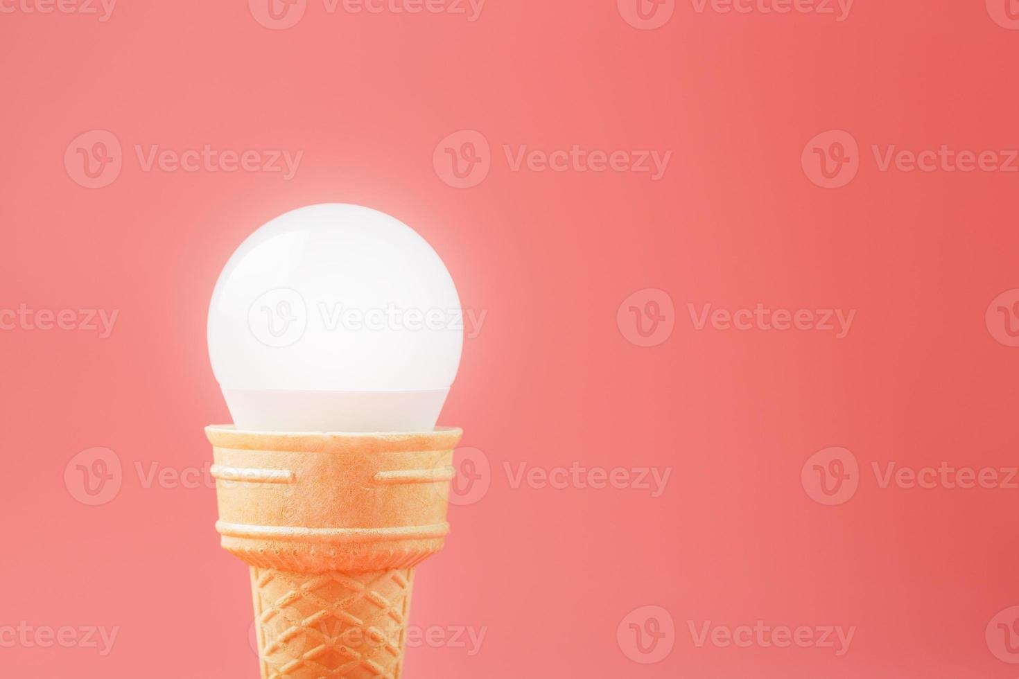 leggero lampadina ghiaccio crema nel un' cialda tazza su un' rosa sfondo. foto