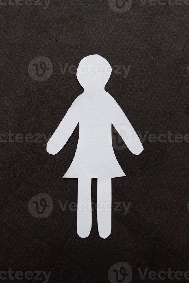 silhouette di un' donna nel vestito di bianca carta, tagliare di mano. nel il centro di verticale foto su nero sfondo