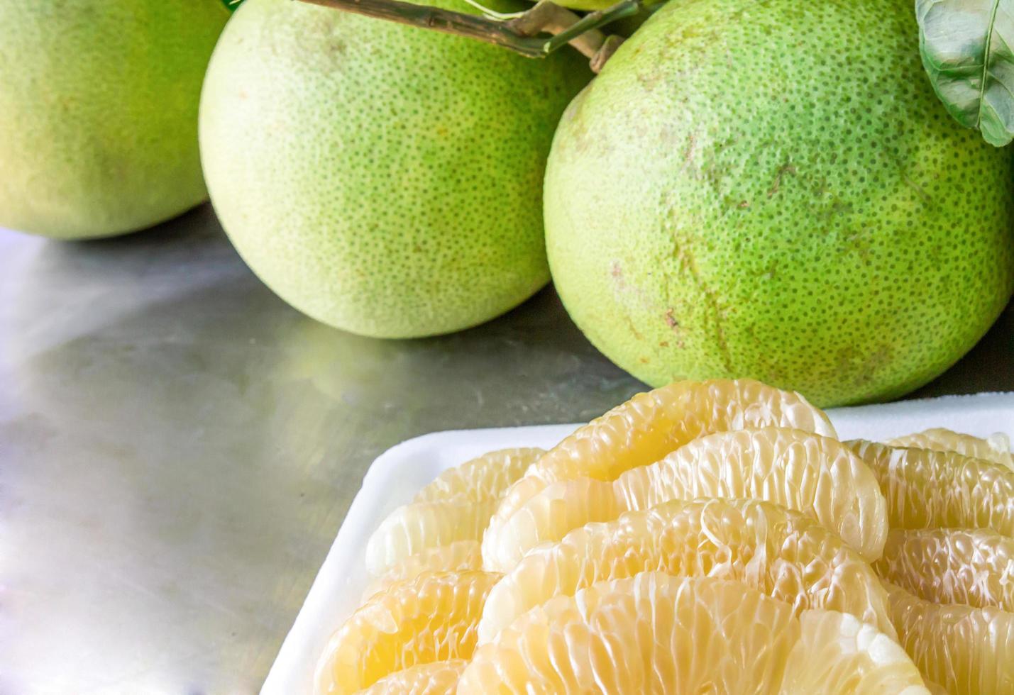 vicino su molti pomelo pelato e pomelo su il tavolo un' frutta a partire dal Asia con un' dolce e acida gusto foto