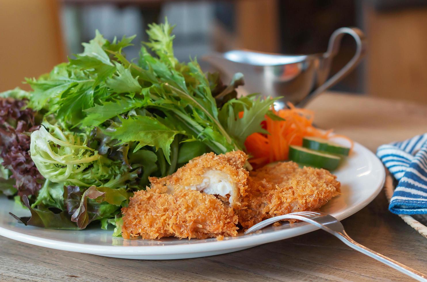 fritte pesce filetto con fresco verdura su bianca piatto foto