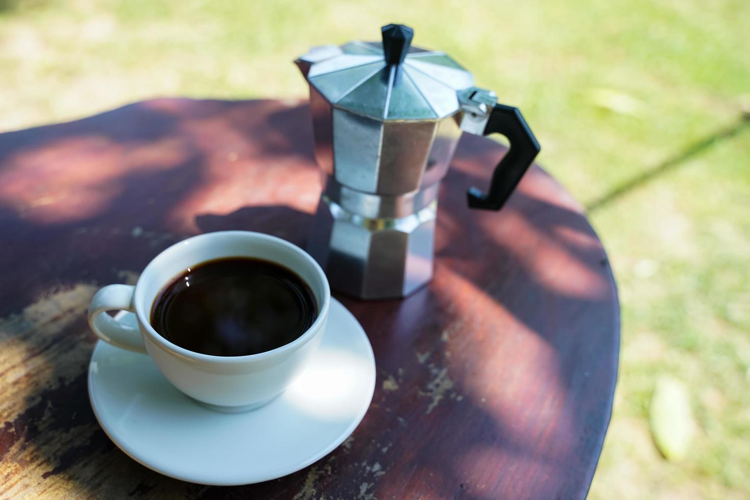 caldo nero caffè nel un' bianca tazza, caffè è un' popolare bevanda tutti al di sopra di il mondo. foto