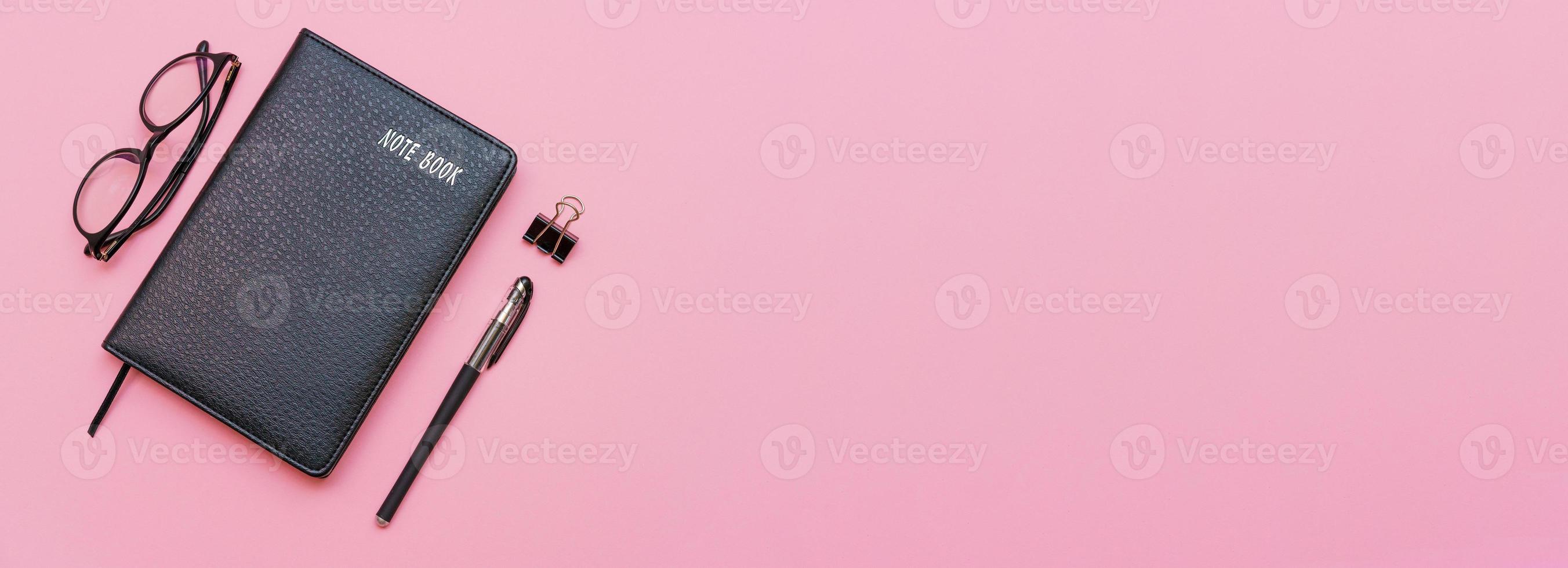 nero taccuino con moderno bicchieri e nero penna isolato su rosa sfondo. foto