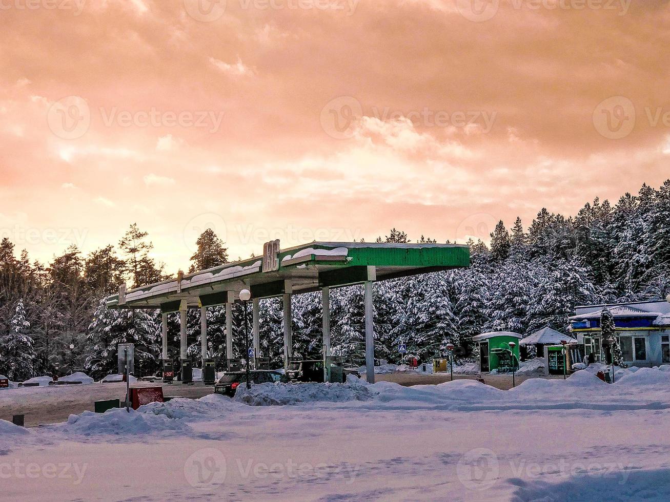 bellissimo piccolo gas stazione per rifornimento carburante macchine con carburante, benzina e diesel a tramonto nel il inverno foto