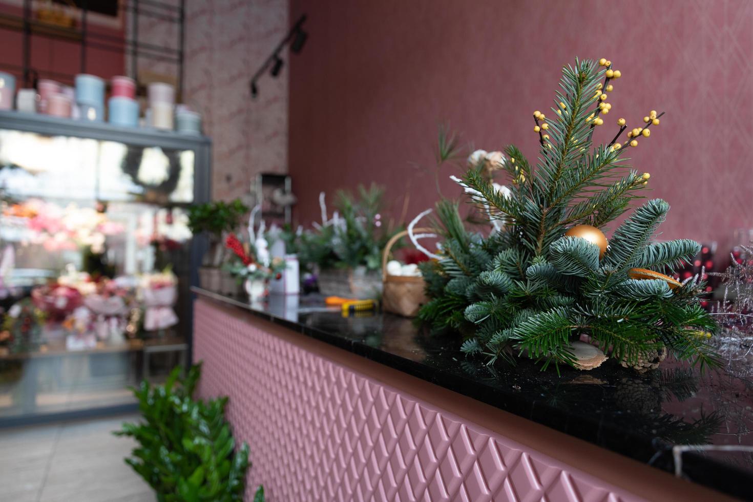 elegante Natale albero preparativi di naturale abete aghi nel il primo piano nel il interno di un' rosa fioraio negozio foto