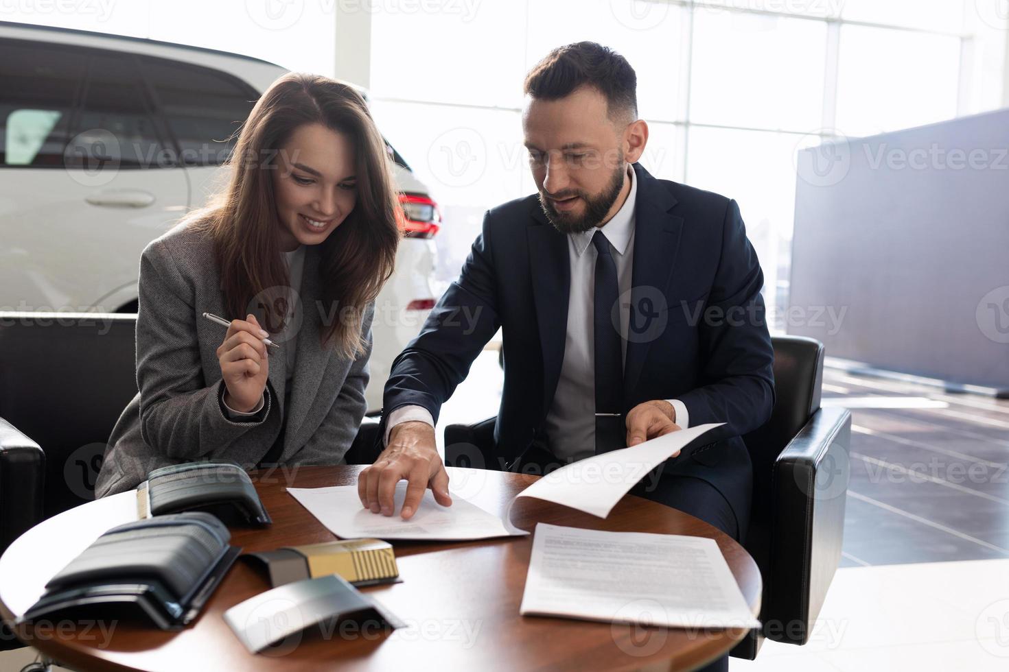 giovane donna acquista un' nuovo auto nel un' auto concessionaria e segni documenti, auto assicurazione concetto foto