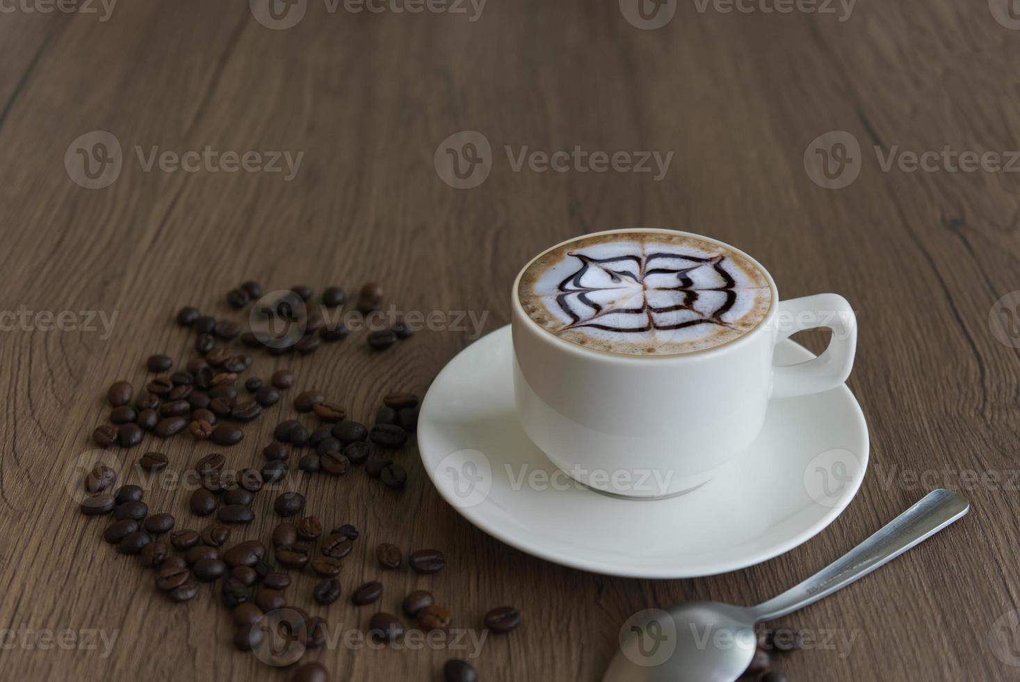 caffè nel un' boccale e fagioli su un' legna grano sfondo foto