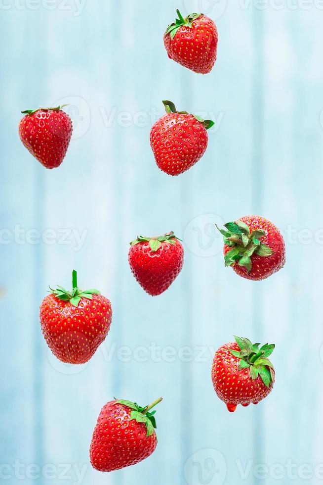 fragola bacca levitante su un' blu sfondo foto