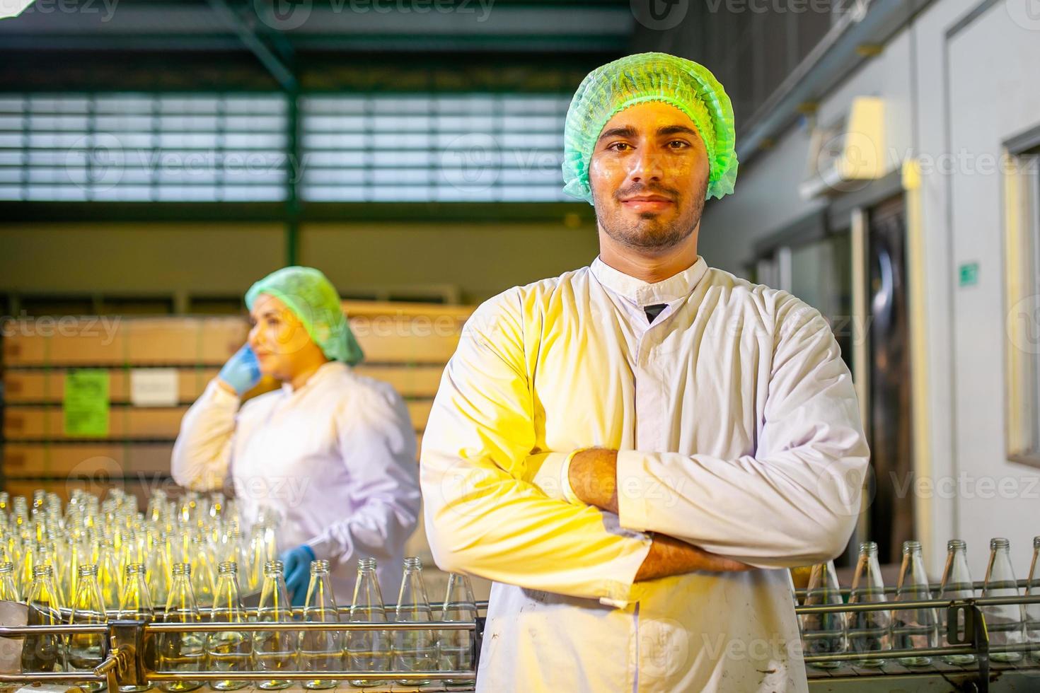 asiatico lavoratori con appunti è controllo Prodotto bottiglie di frutta succo su il produzione linea nel il bevanda fabbrica. fabbricante controlli qualità di cibo industria. foto