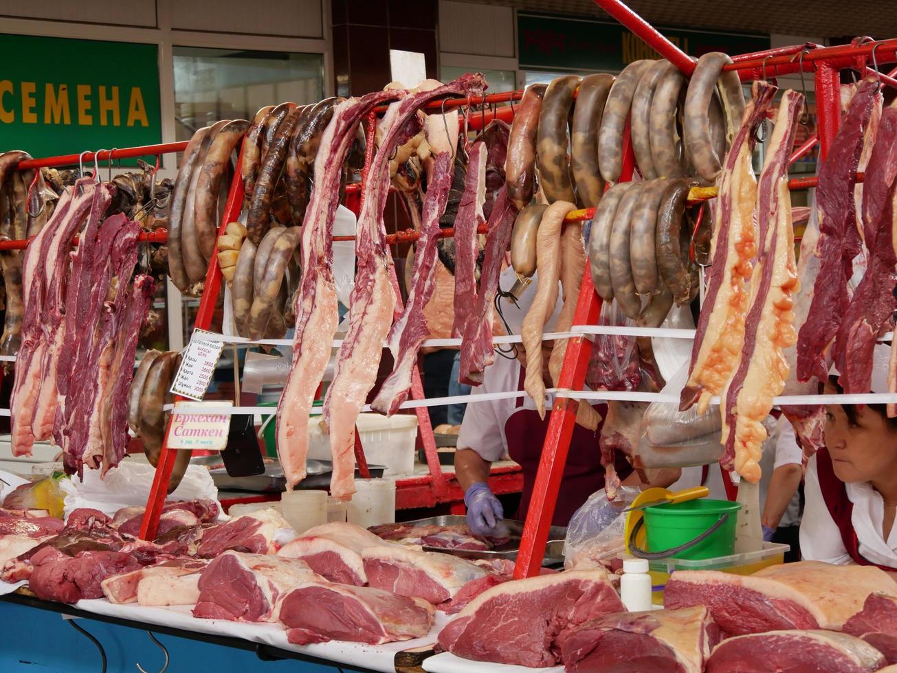 Almaty, kazakistan, 2019 - persone nel il carne sezione di il famoso verde bazar di Almaty, kazakistan, con merce su Schermo. foto