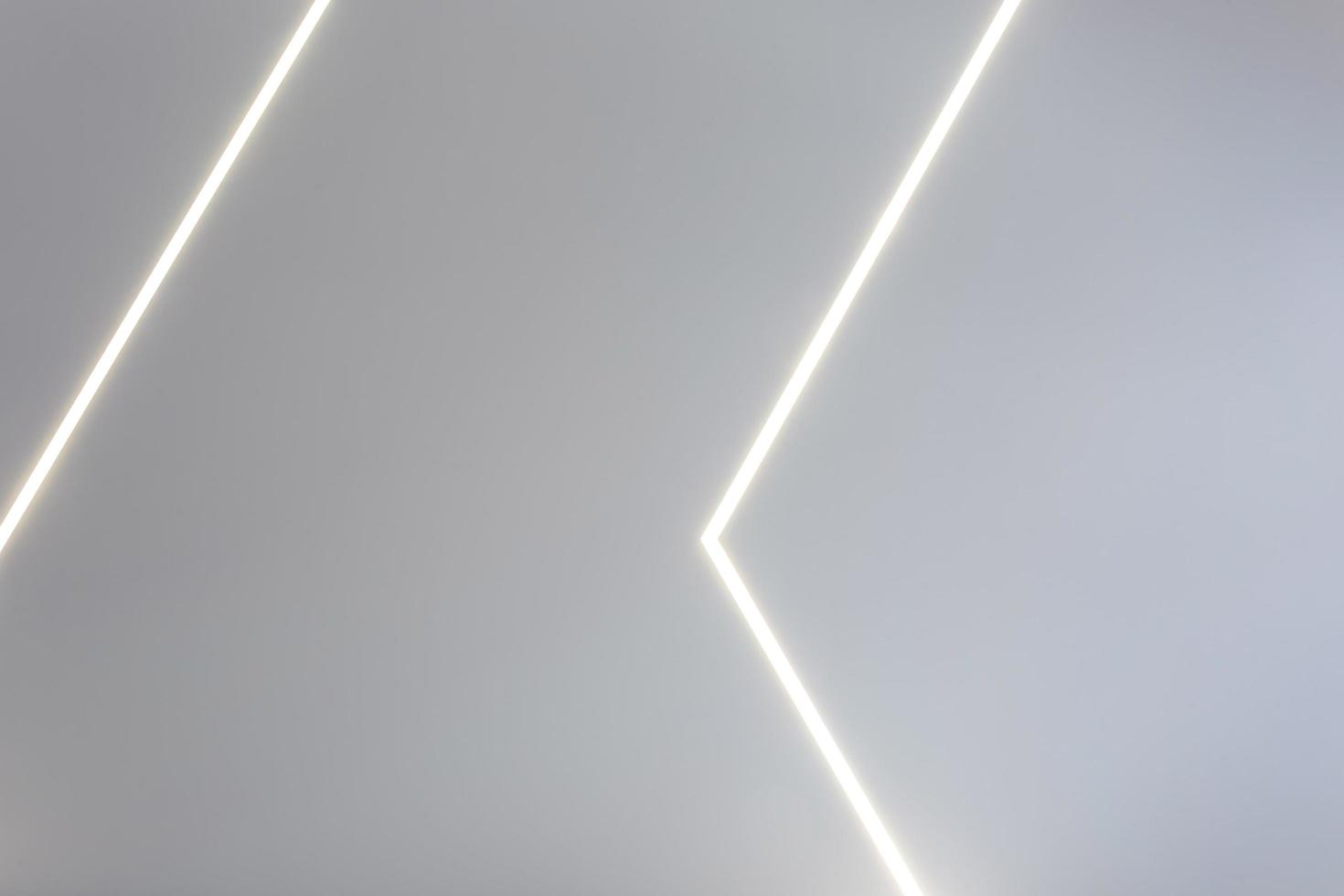 controsoffitto con lampade alogene e costruzione di cartongesso in una stanza vuota in appartamento o casa. soffitto teso bianco e di forma complessa. foto