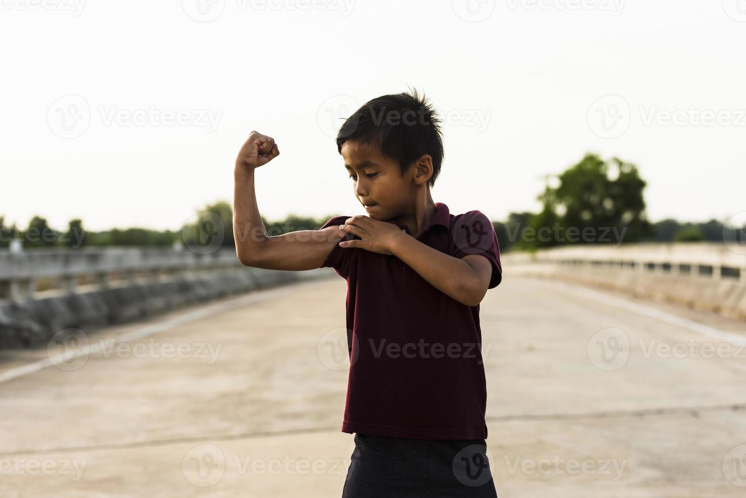 un' ragazzo mostrando il suo braccio muscoli un' immagine di un asiatico ragazzo. foto