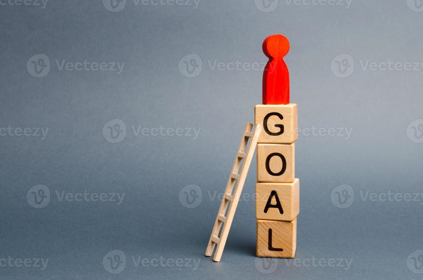 il rosso figura di un' uomo sta su un' Torre di cubi con il parola obiettivo. comando abilità. il concetto di raggiungimento il obiettivo, dedizione e diligenza, superamento ostacoli e pensiero straordinariamente foto