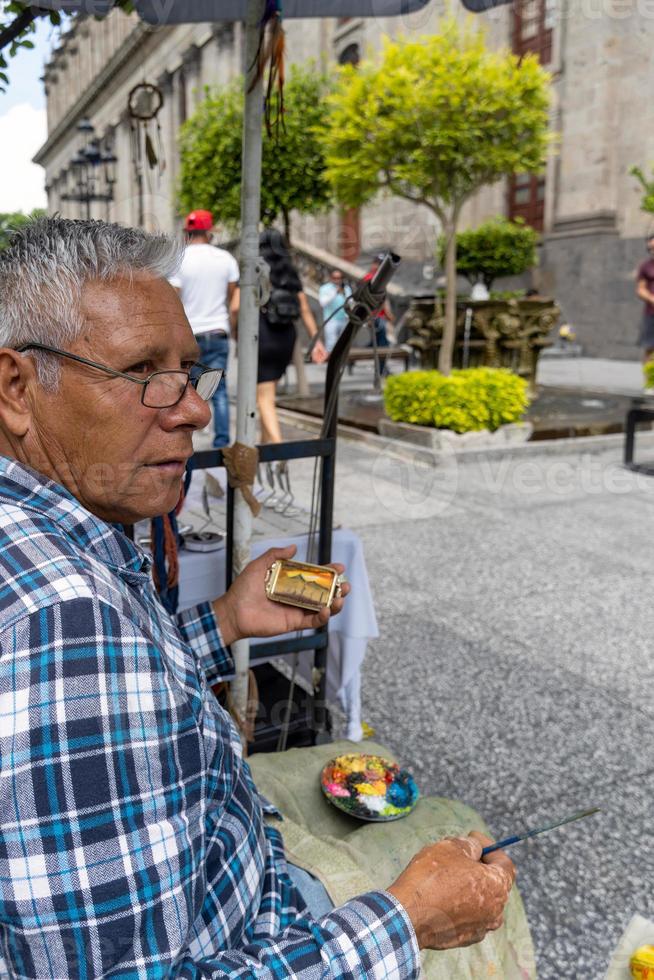 anziano strada artista, Marrone latino uomo, pittura immagini su il strada, Messico foto