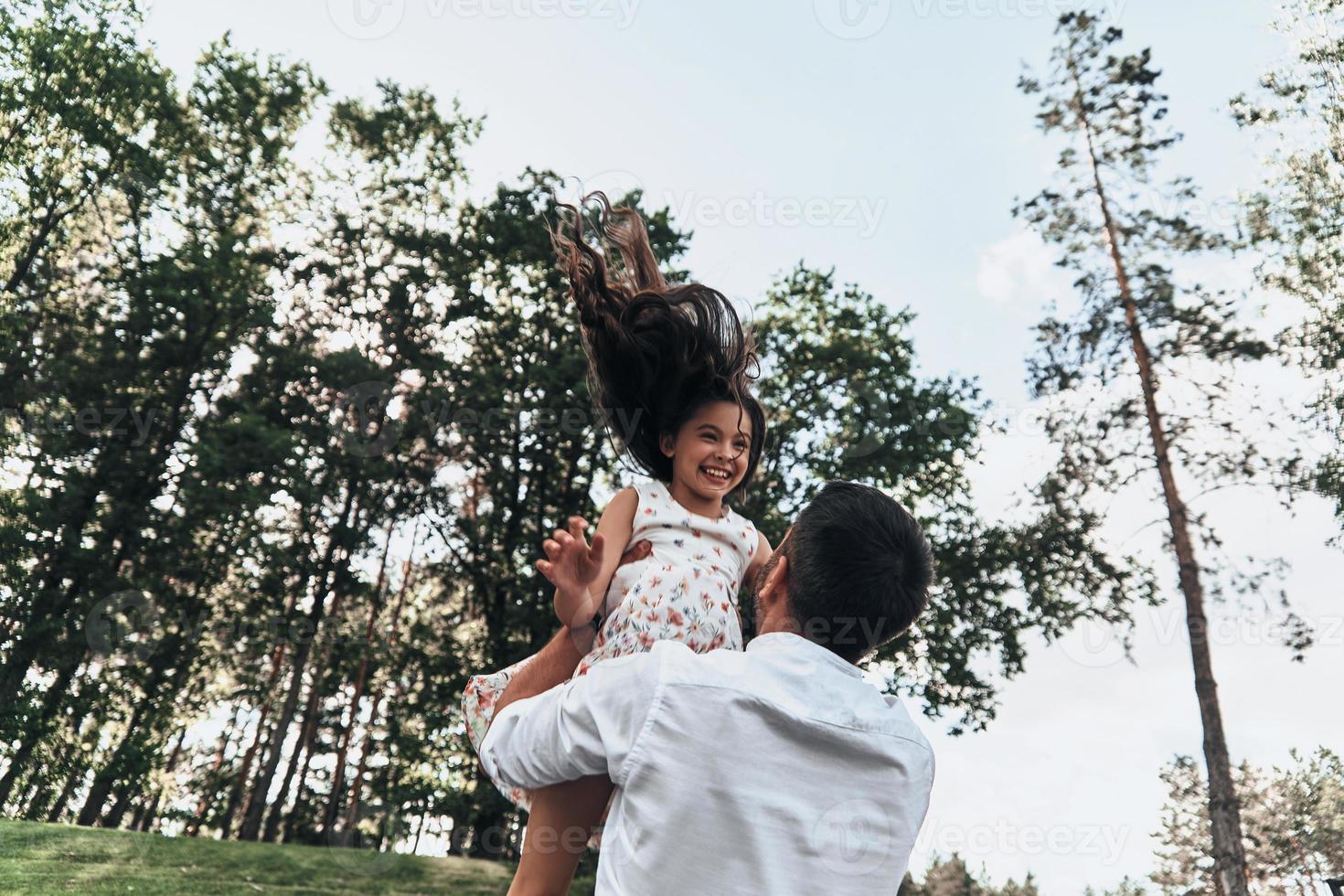 papà è sua migliore amico. giovane amorevole padre trasporto il suo sorridente figlia mentre la spesa gratuito tempo all'aperto foto