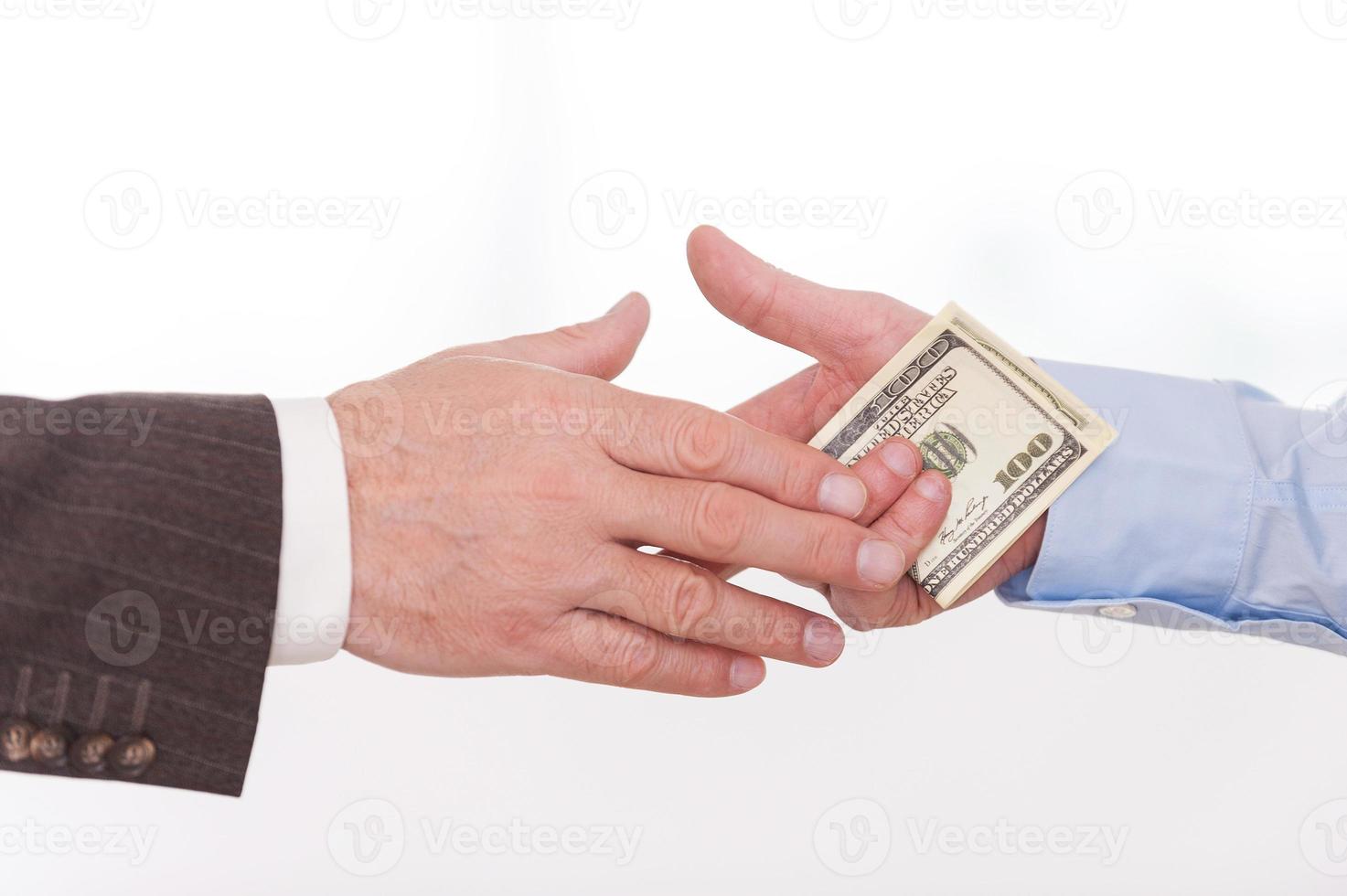 corruzione. avvicinamento di uomo d'affari dando i soldi per un altro uomo mentre stretta di mano foto