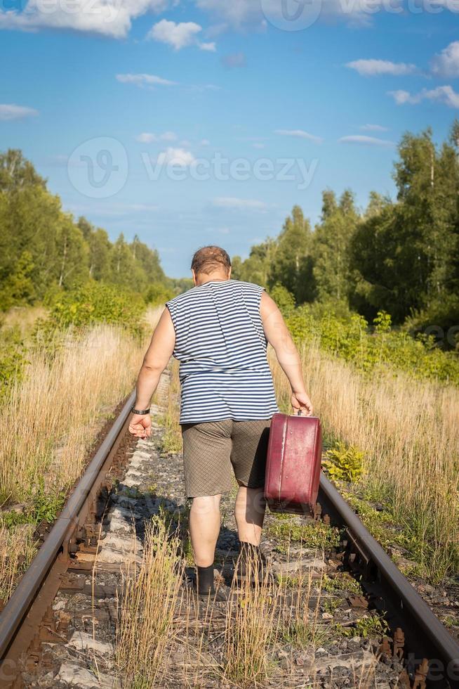 uomo con valigia rotaie foto