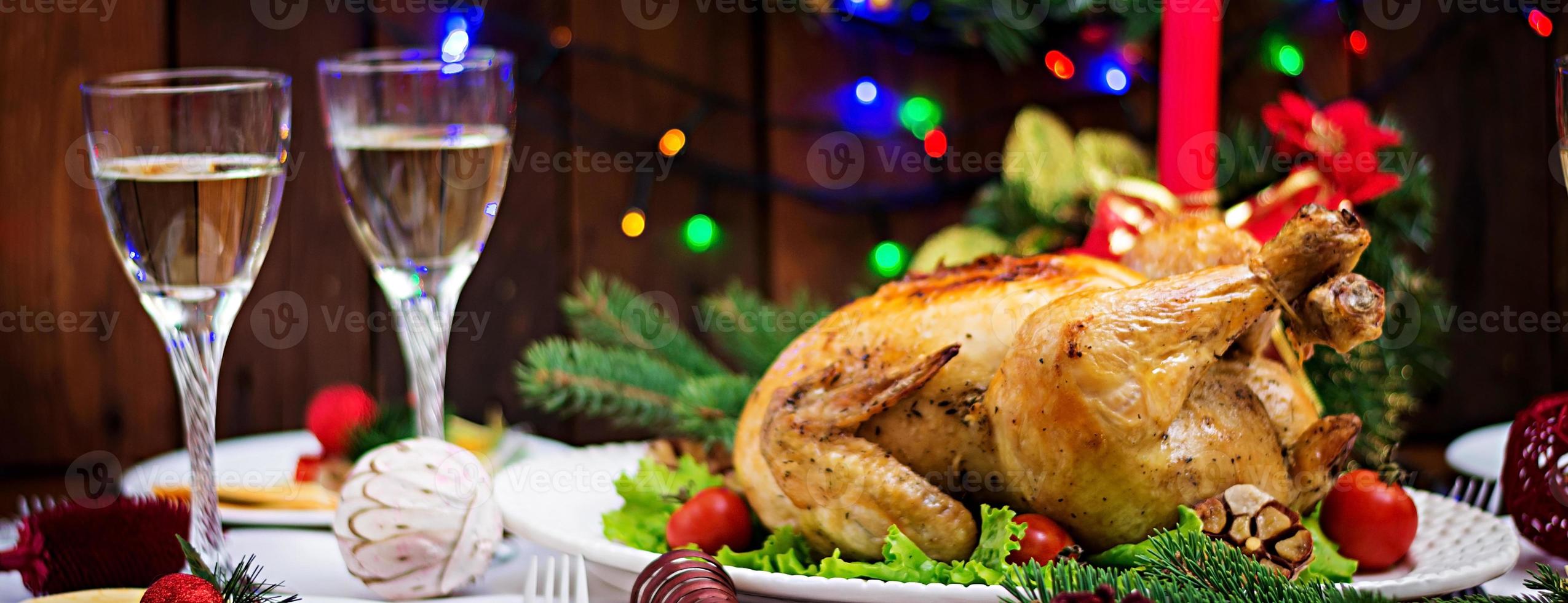 al forno tacchino o pollo. il Natale tavolo è servito con un' tacchino, decorato con luminosa orpello e candele. fritte pollo, tavolo. Natale cena. bandiera foto