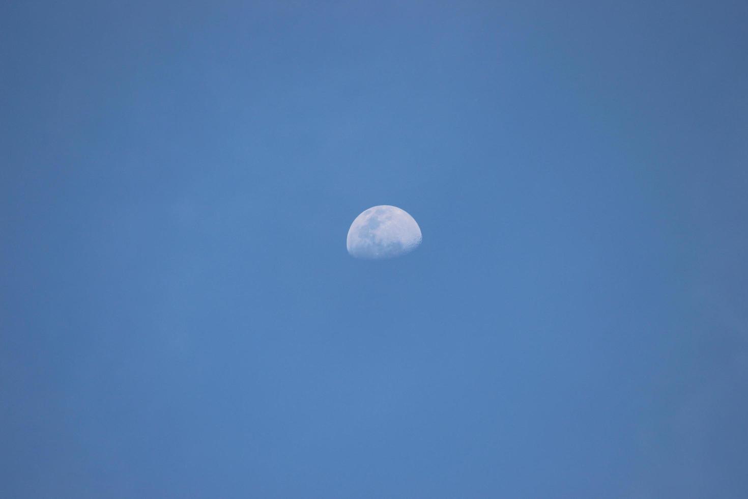 mezza luna sul cielo blu alla luce del giorno foto