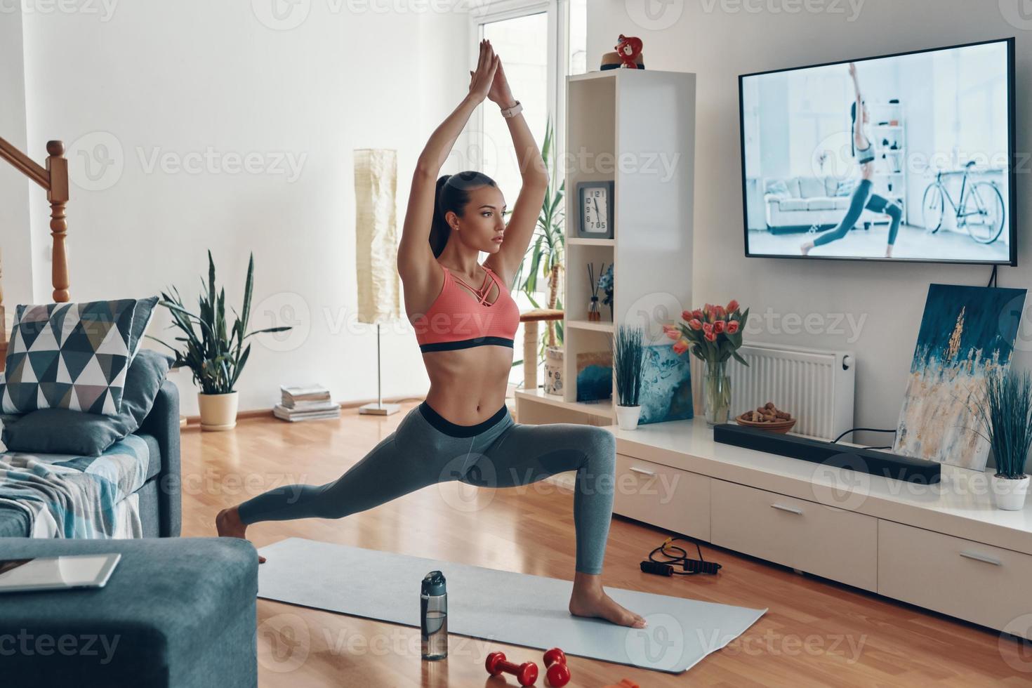 attraente in forma giovane donna nel gli sport capi di abbigliamento Lavorando su mentre la spesa tempo a casa foto