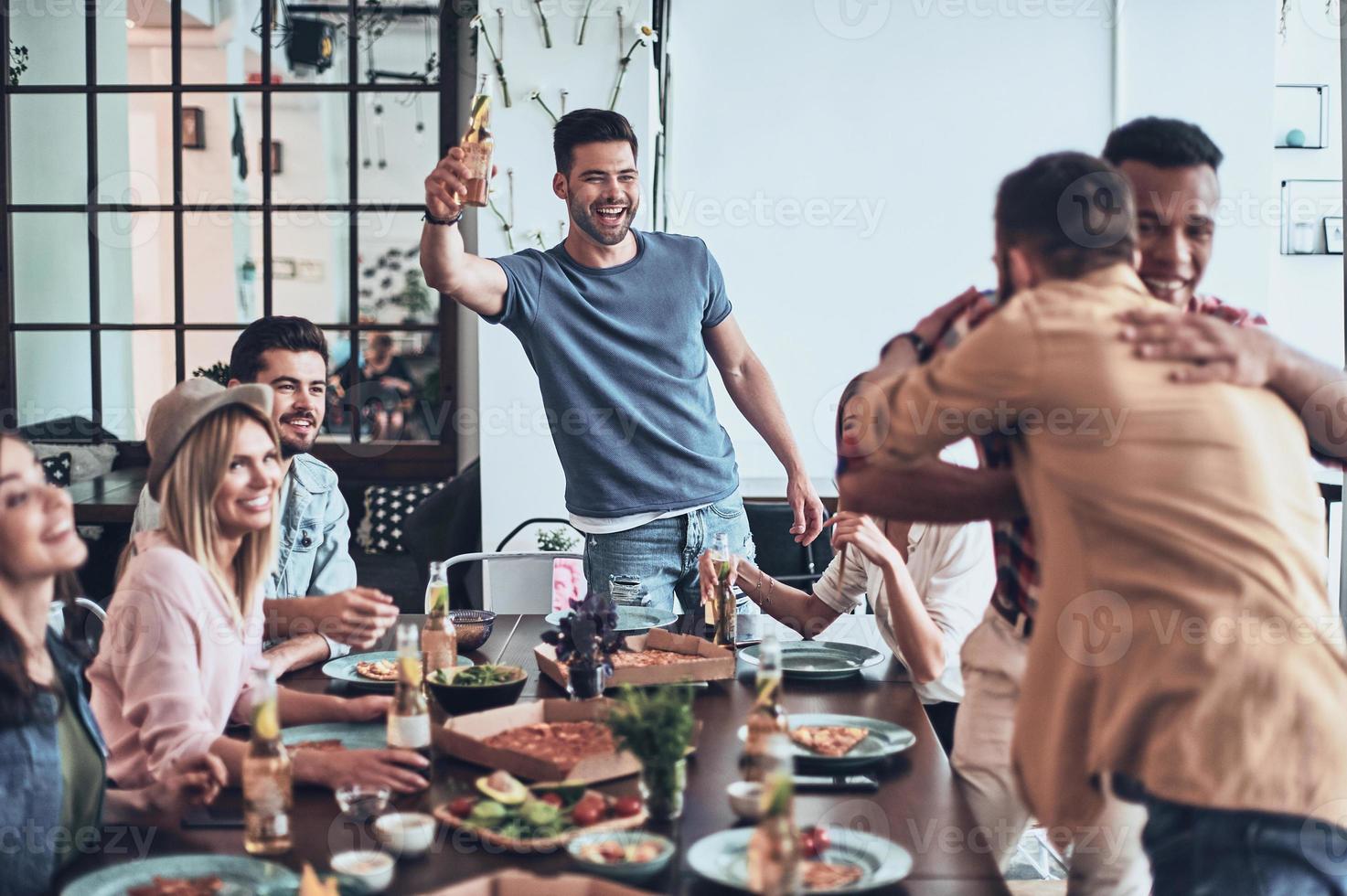 superiore Visualizza di giovane persone nel casuale indossare Esprimere a gesti e sorridente mentre avendo un' cena festa in casa foto