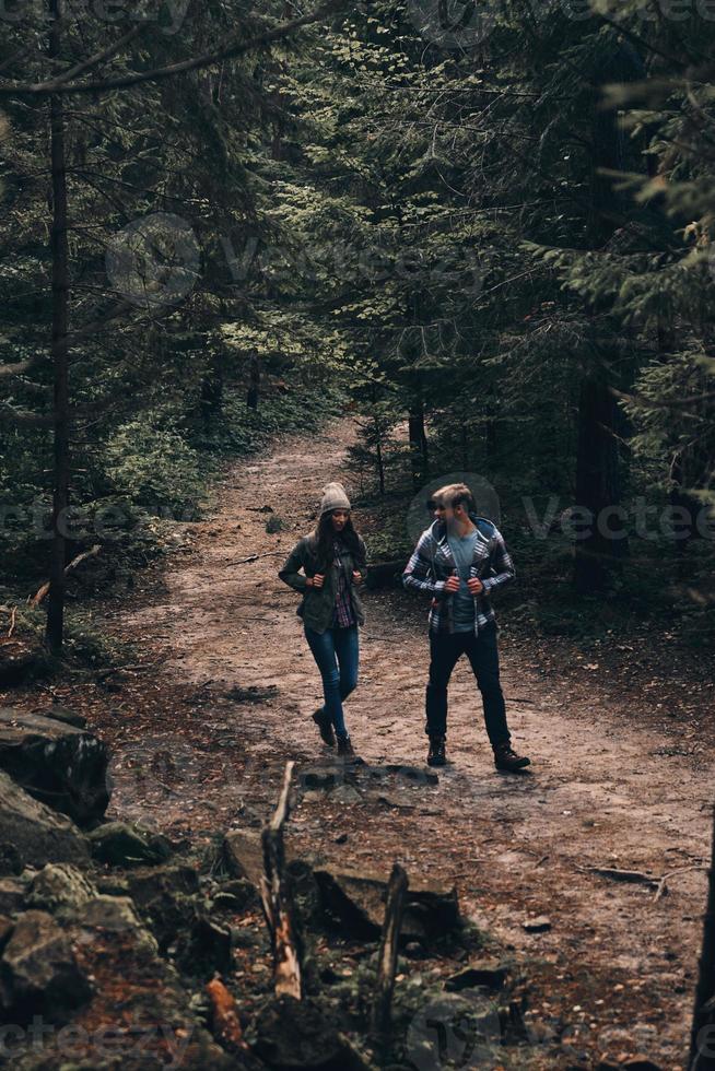 avventuroso coppia. pieno lunghezza di bellissimo giovane coppia escursioni a piedi insieme nel il boschi mentre godendo loro viaggio foto