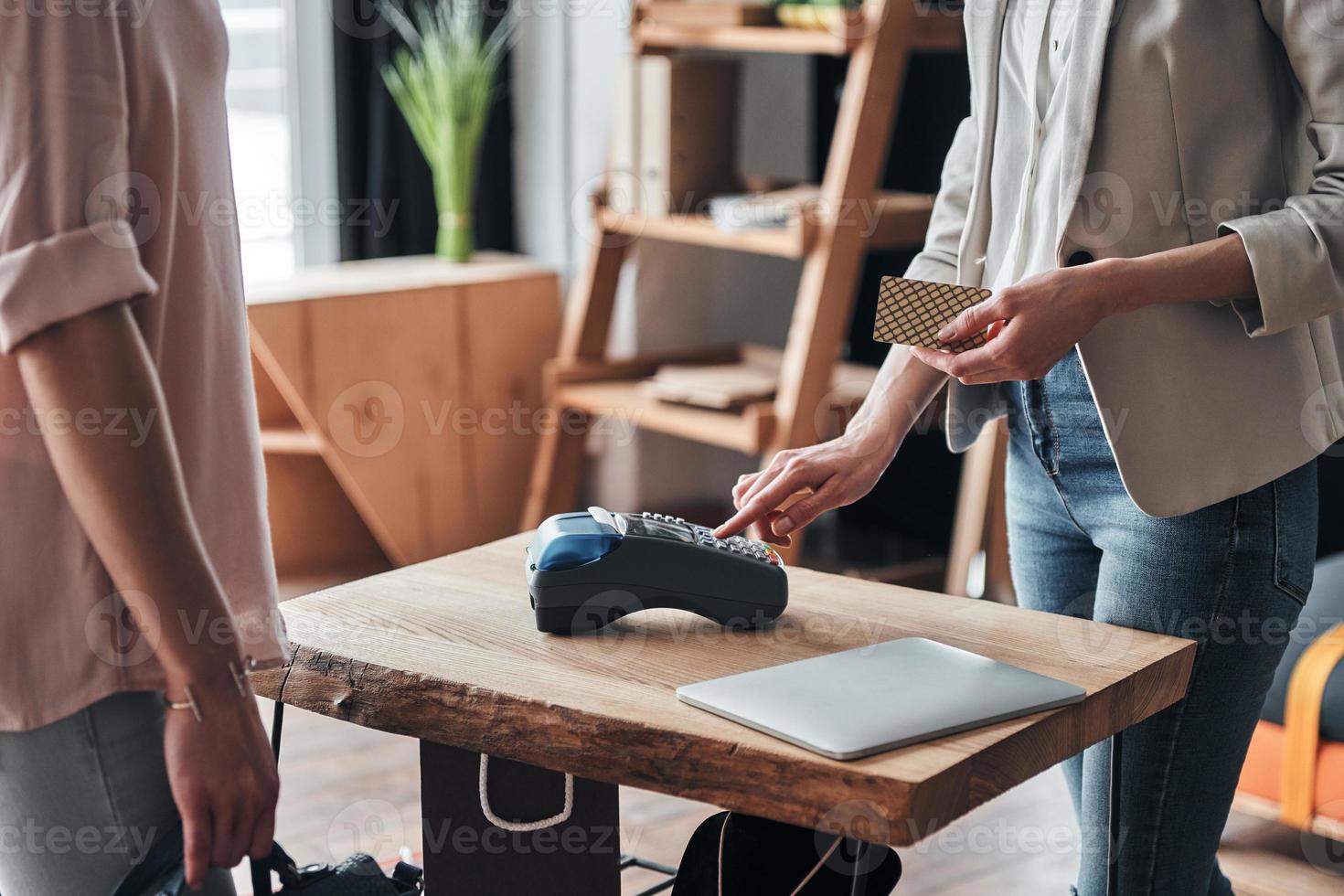 pagamenti siamo facile. vicino su di venditore utilizzando pagamento terminale per Confermare il Acquista mentre Lavorando nel il moda boutique foto