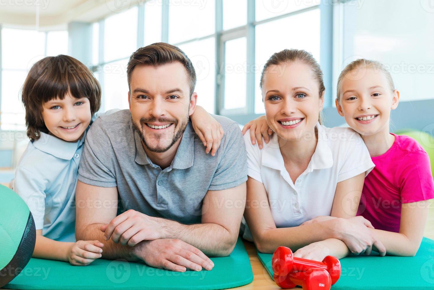 contento famiglia nel fitness club. contento sportivo famiglia bonding per ogni altro mentre dire bugie su esercizio stuoia insieme foto