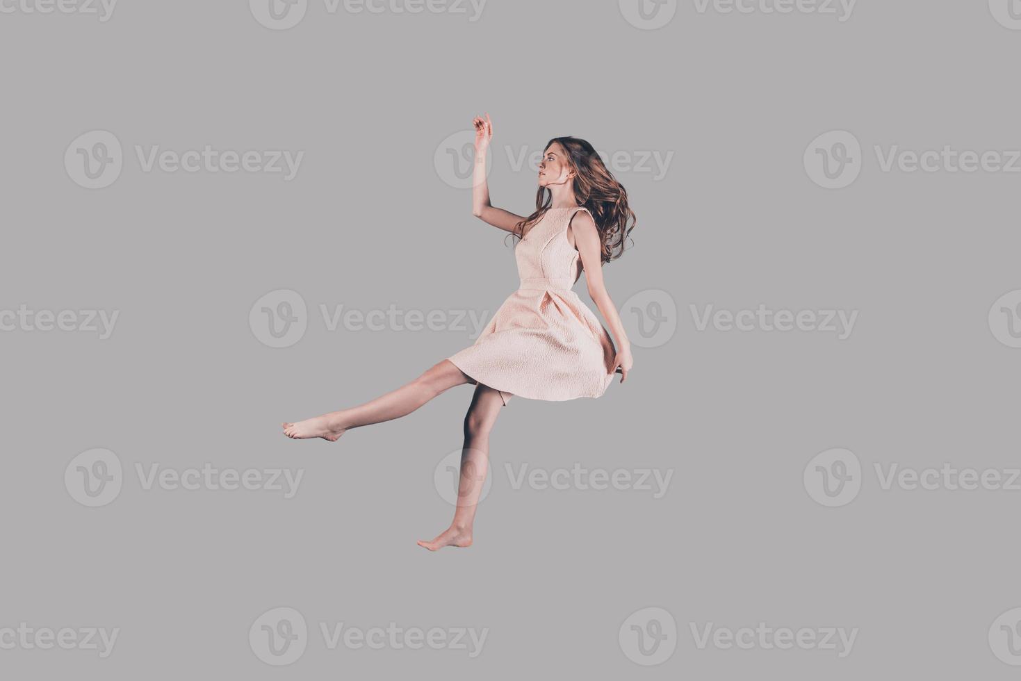 sua vita nel movimento. studio tiro di attraente giovane donna librarsi nel aria foto